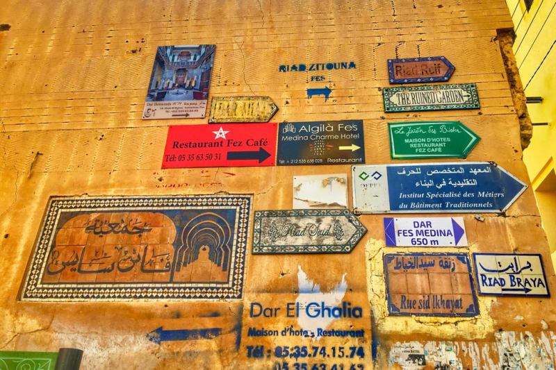 A wall in Fez with signs posted on it to all sorts of locations