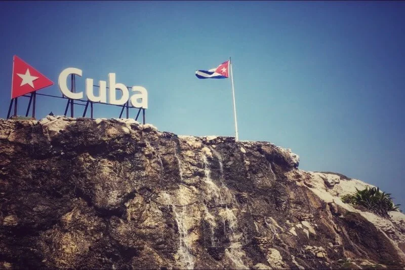 Sign of Cuba with a flag on a pole on a cliff