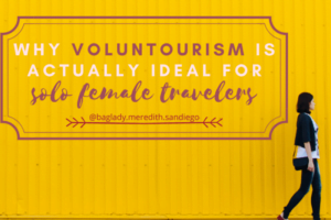 why voluntourism is actually ideal for solo female travelers pin by Meredith with a galvanised yellow walk as a background and a woman walking along in right foreground