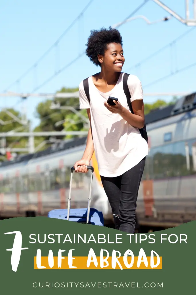 7 Sustainable Tips for LIfe Abroad Curiositysavestravel.com with a traveler and her suitcase and phone in the background