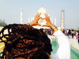 Meredith making a heart shape with her hands at the taj mahal